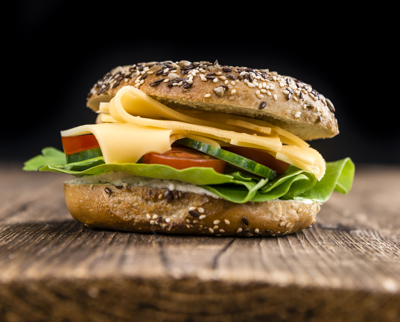 Wooden table with Cheese Bagel (selective focus; detailed close-up shot)